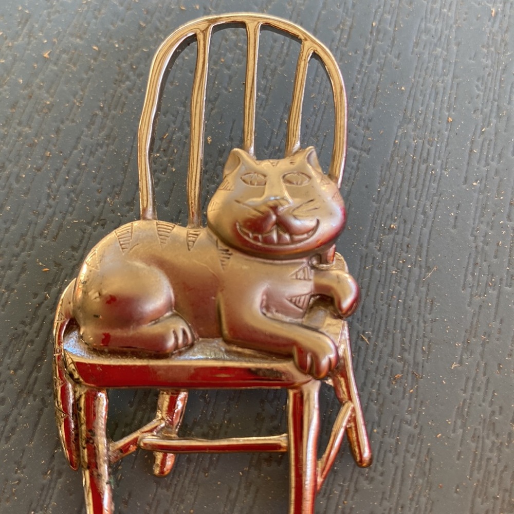 JJ mischievous grinning cat in a chair brooch. My guess is this is vintage.